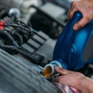 Cropped shot of automechanic changing motor oil in a repair shop.