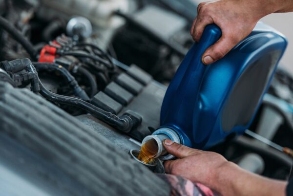 Cropped shot of automechanic changing motor oil in a repair shop.